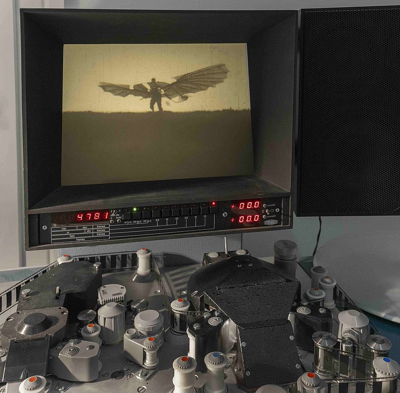 Ein Bild aus einem Film zeigt einen Mann mit einem Segelflugapparat.
